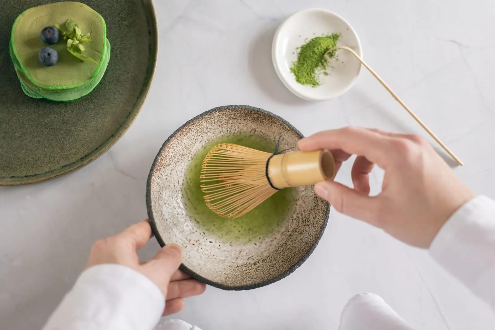 以茶筅在茶碗中击拂抹茶的俯拍画面